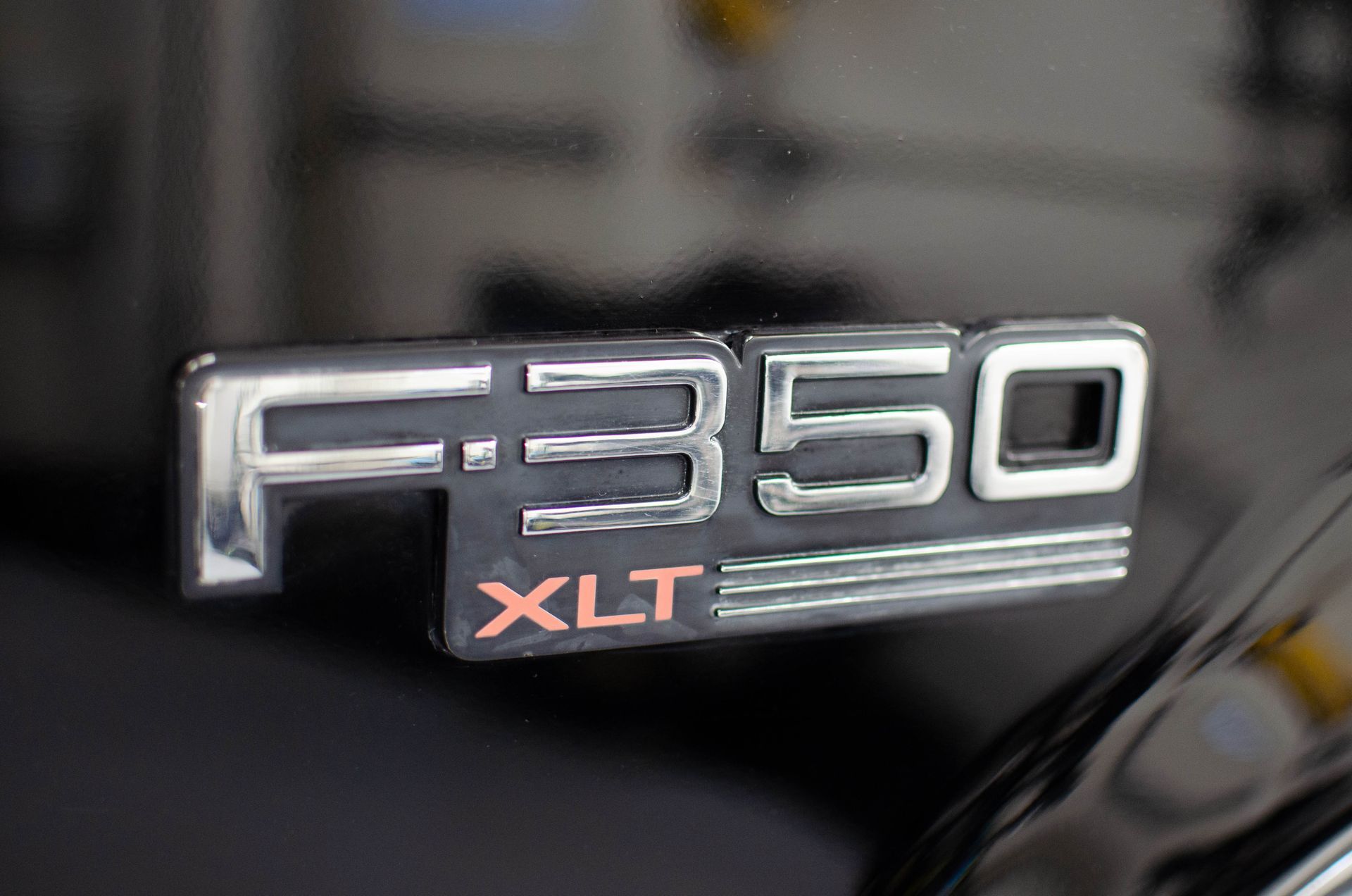 Chrome F-350 XLT badge on a black vehicle