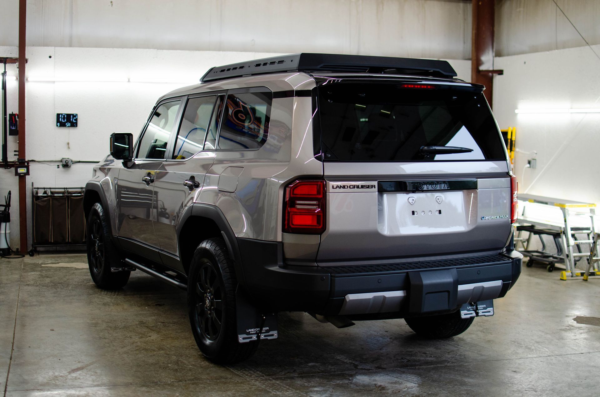 Silver SUV parked in a garage, rear three-quarter view.