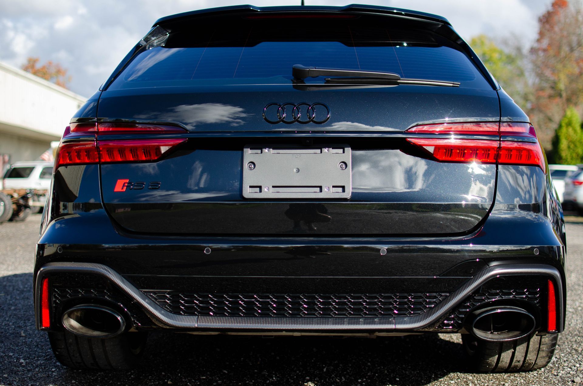 Rear view of a black Audi SUV with red taillights and dual exhausts, parked outdoors