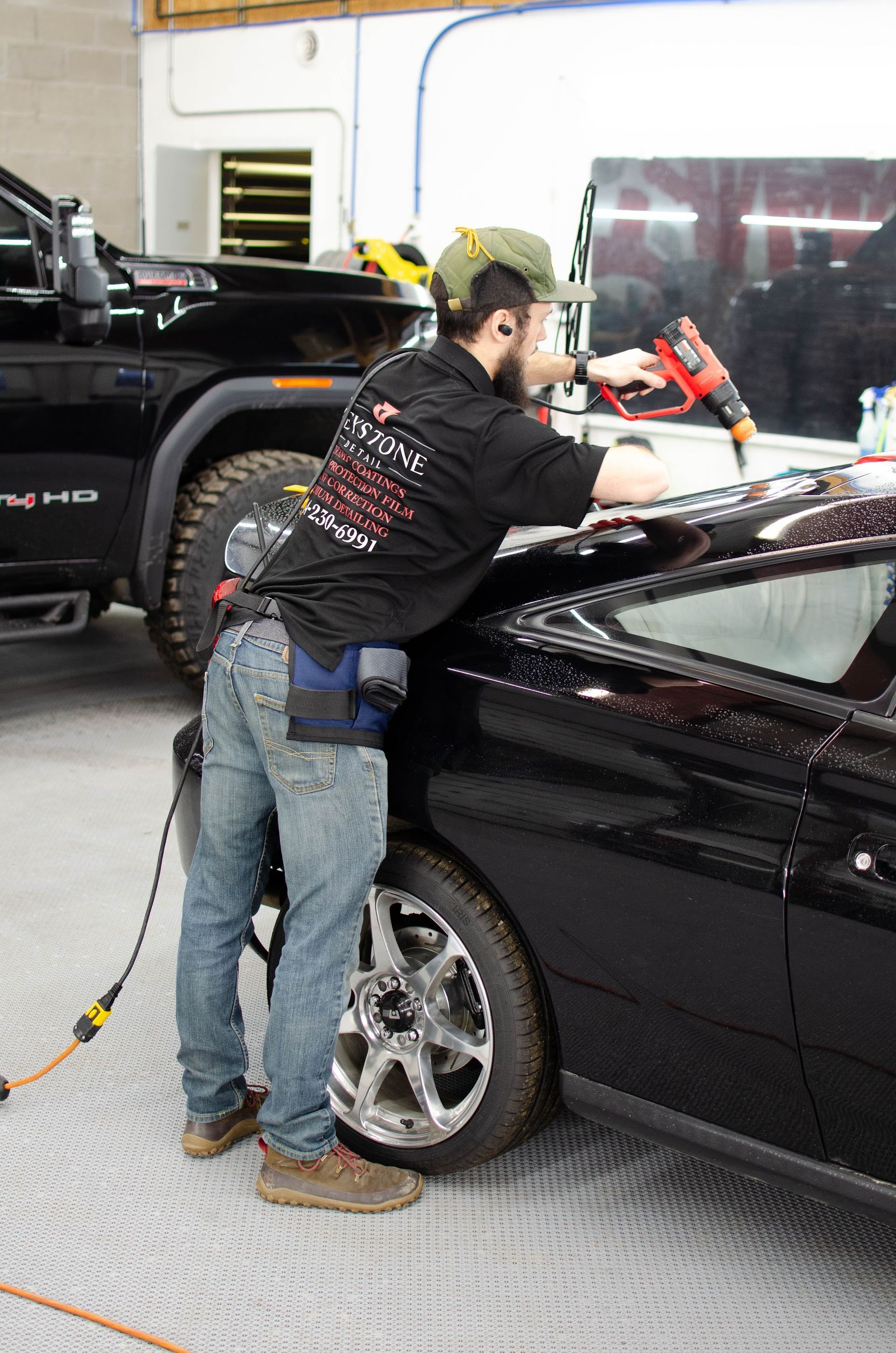 Keystone Detail installer heat-shrinking window tint on a coupe in Waterford, PA
