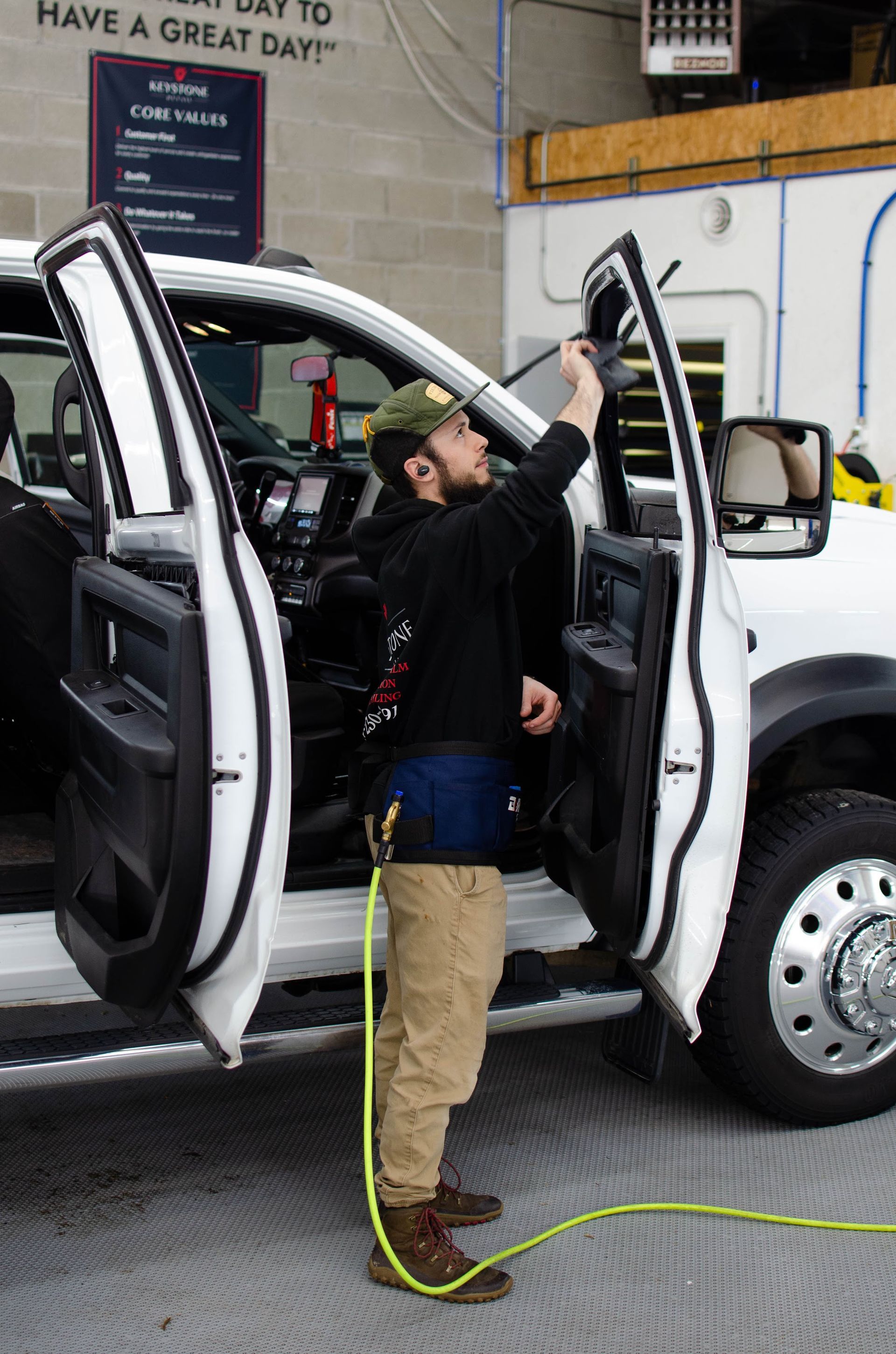 Installer applying front door window tint to a RAM 2500 at Keystone Detail in Waterford, PA