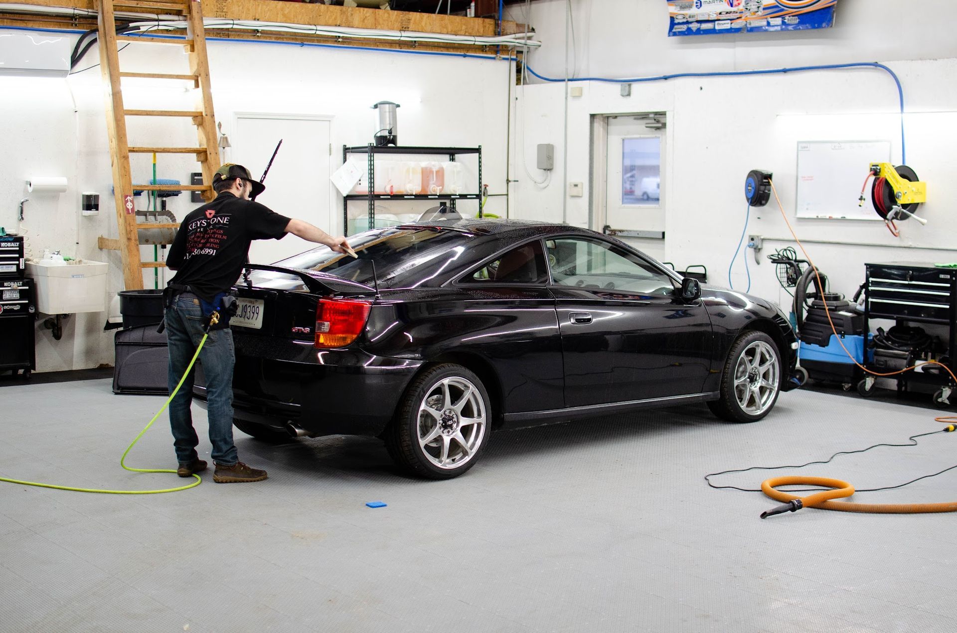 Keystone Detail installer applying window tint to a coupe in the Waterford, PA shop