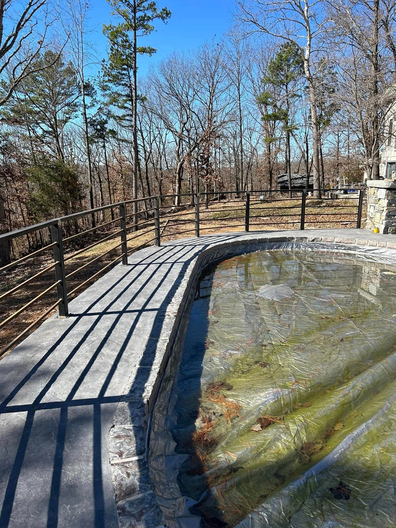 Curved boardwalk beside a frozen pond in a wooded park on a sunny winter day