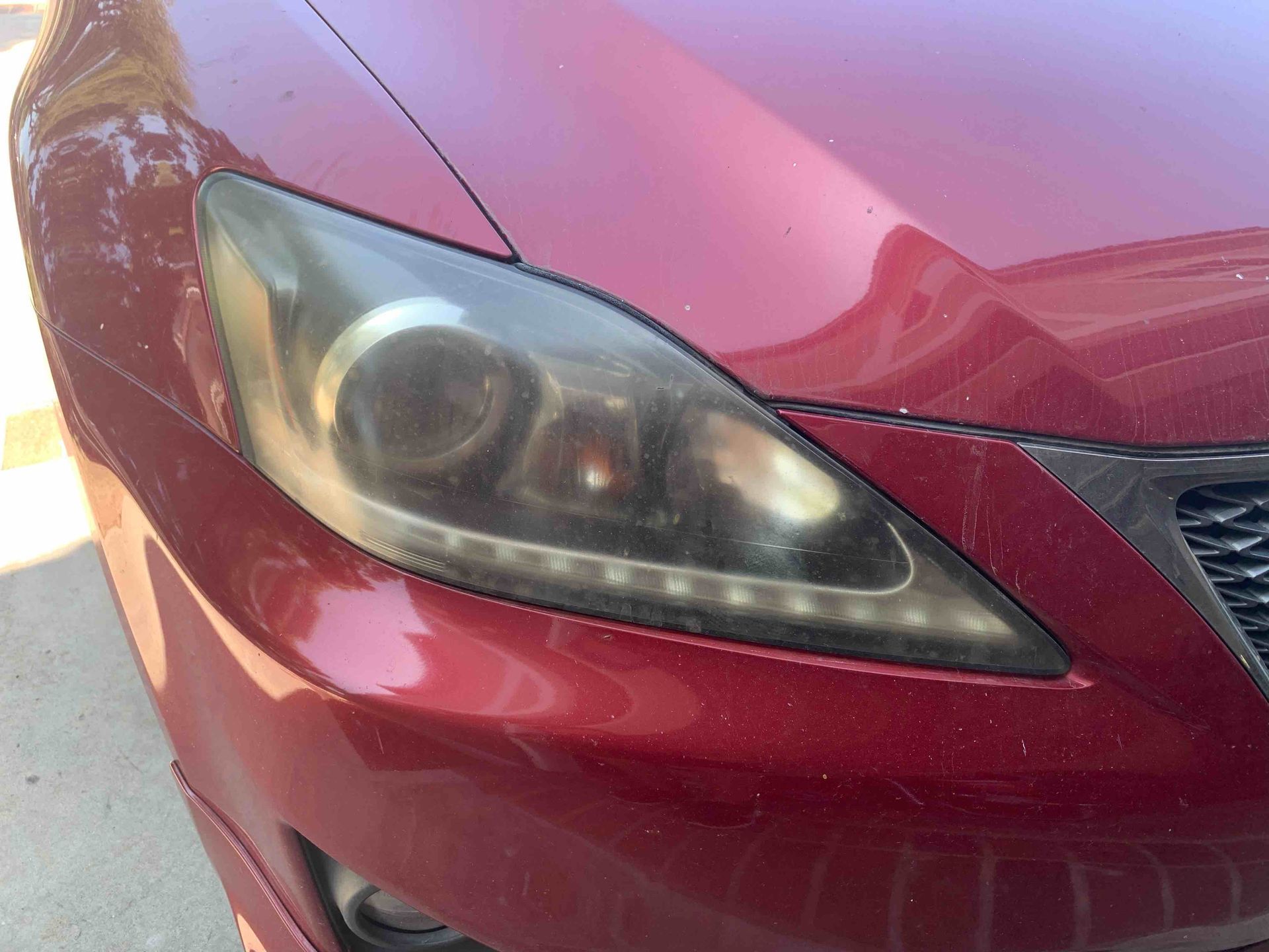 A close-up view of the front headlight assembly on a white and gray vehicle.