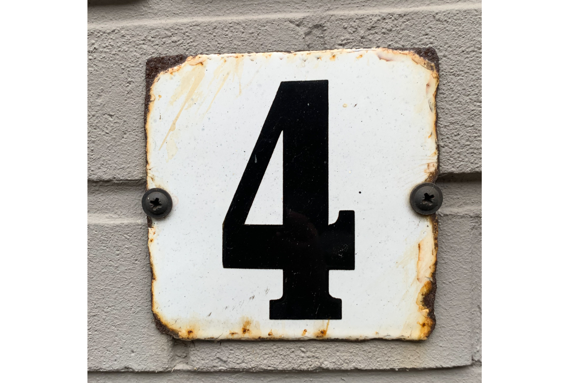 Witte metalen nummerplaat met een zwarte