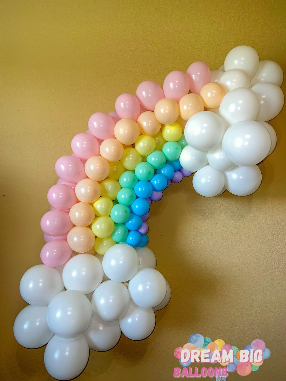 A rainbow made out of balloons on a wall