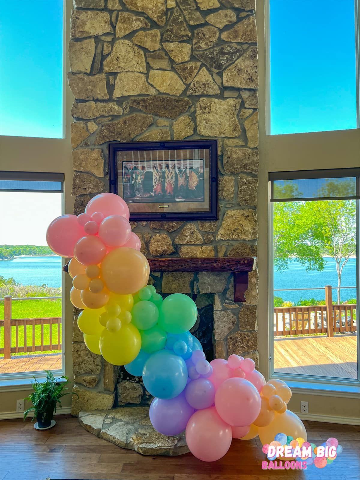 a bunch of balloons are sitting in front of a fireplace in a living room