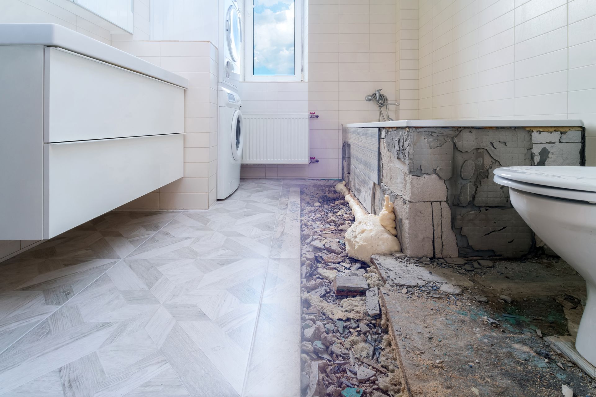 Salle de bain partiellement rénovée : nouveau meuble-lavabo blanc et revêtement de sol à côté d’une baignoire endommagée