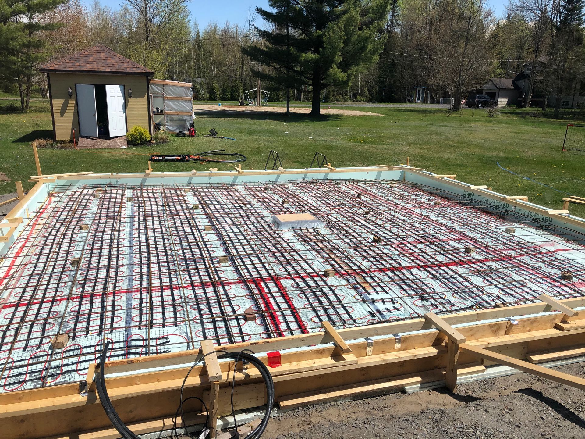 Fondation préparée pour le coulage du béton avec tubes de chauffage radiant.
