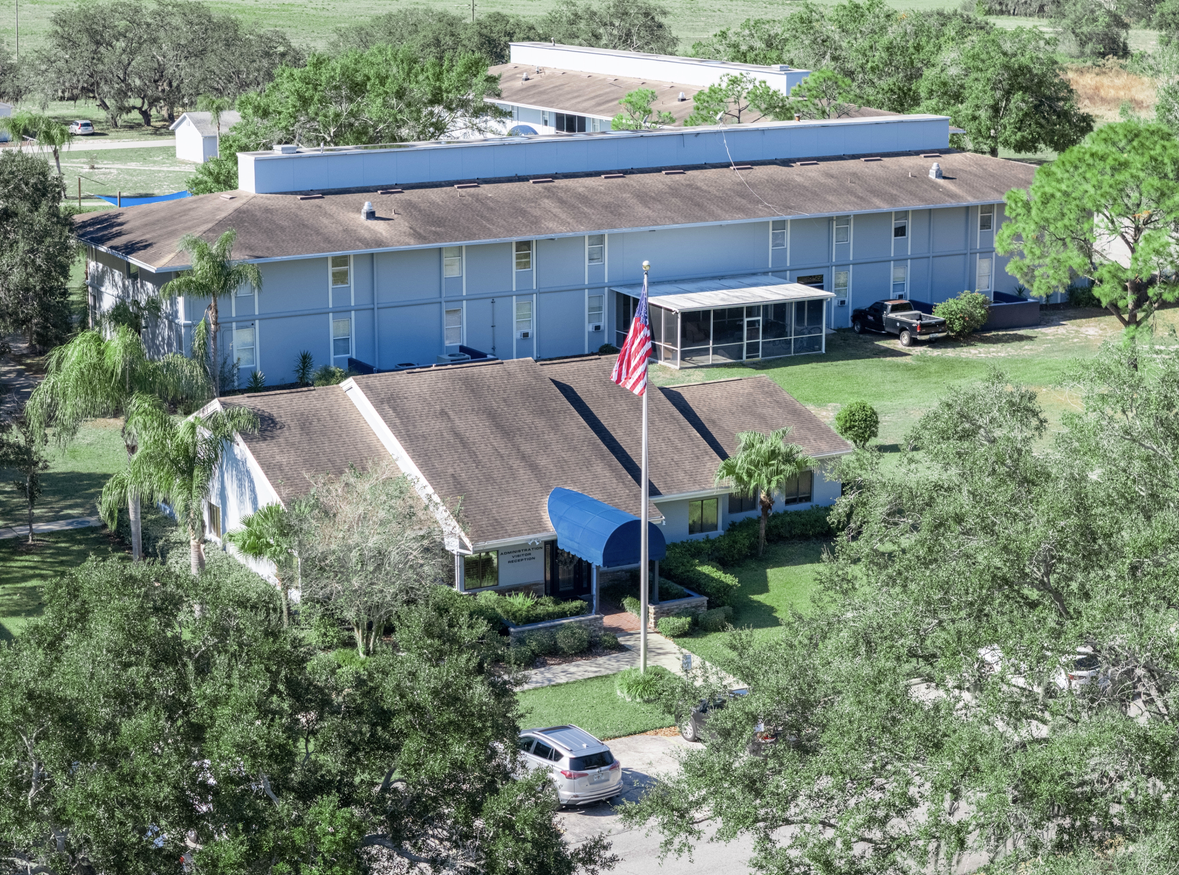 A large empty garage with the words `` orange blossom painting '' written on the floor.