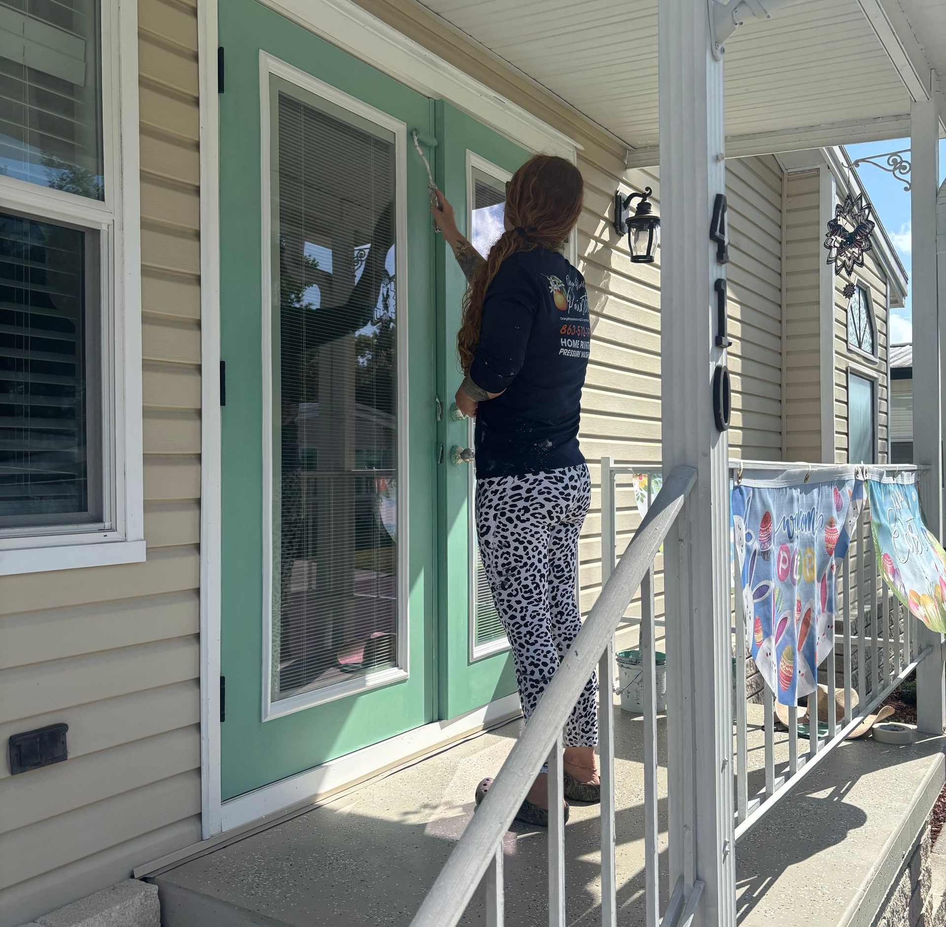 A man is holding a paint roller and a color palette