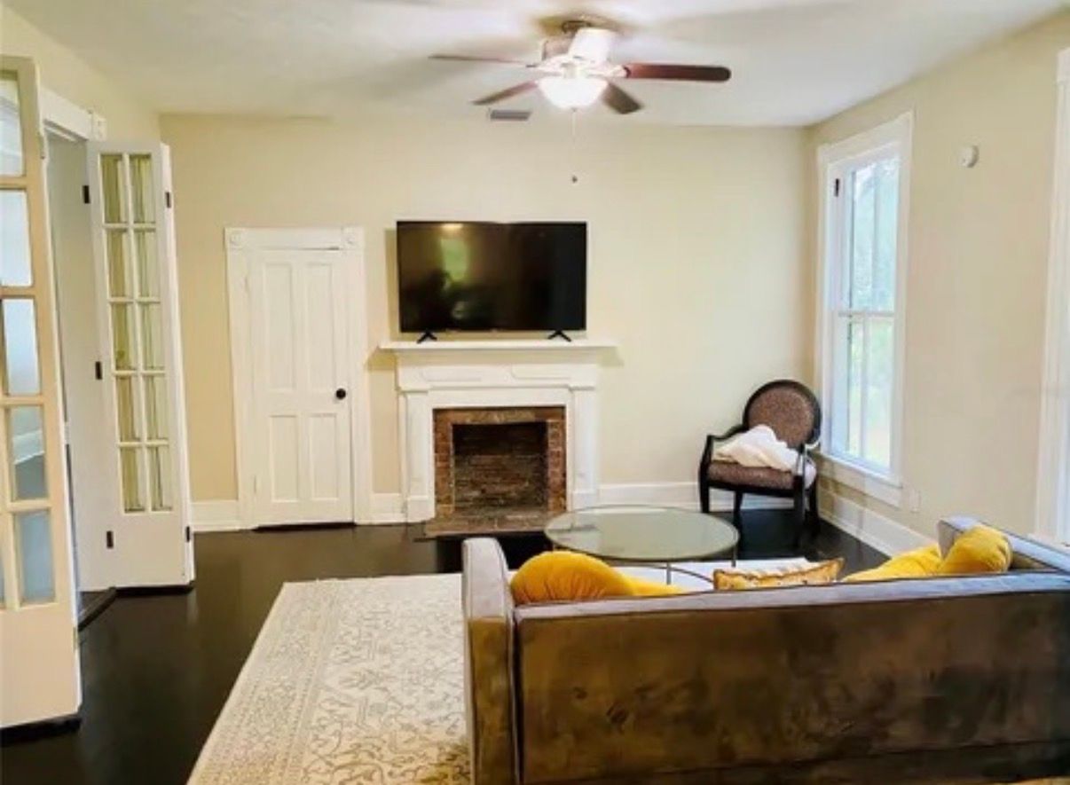 An empty living room with hardwood floors and a fireplace.