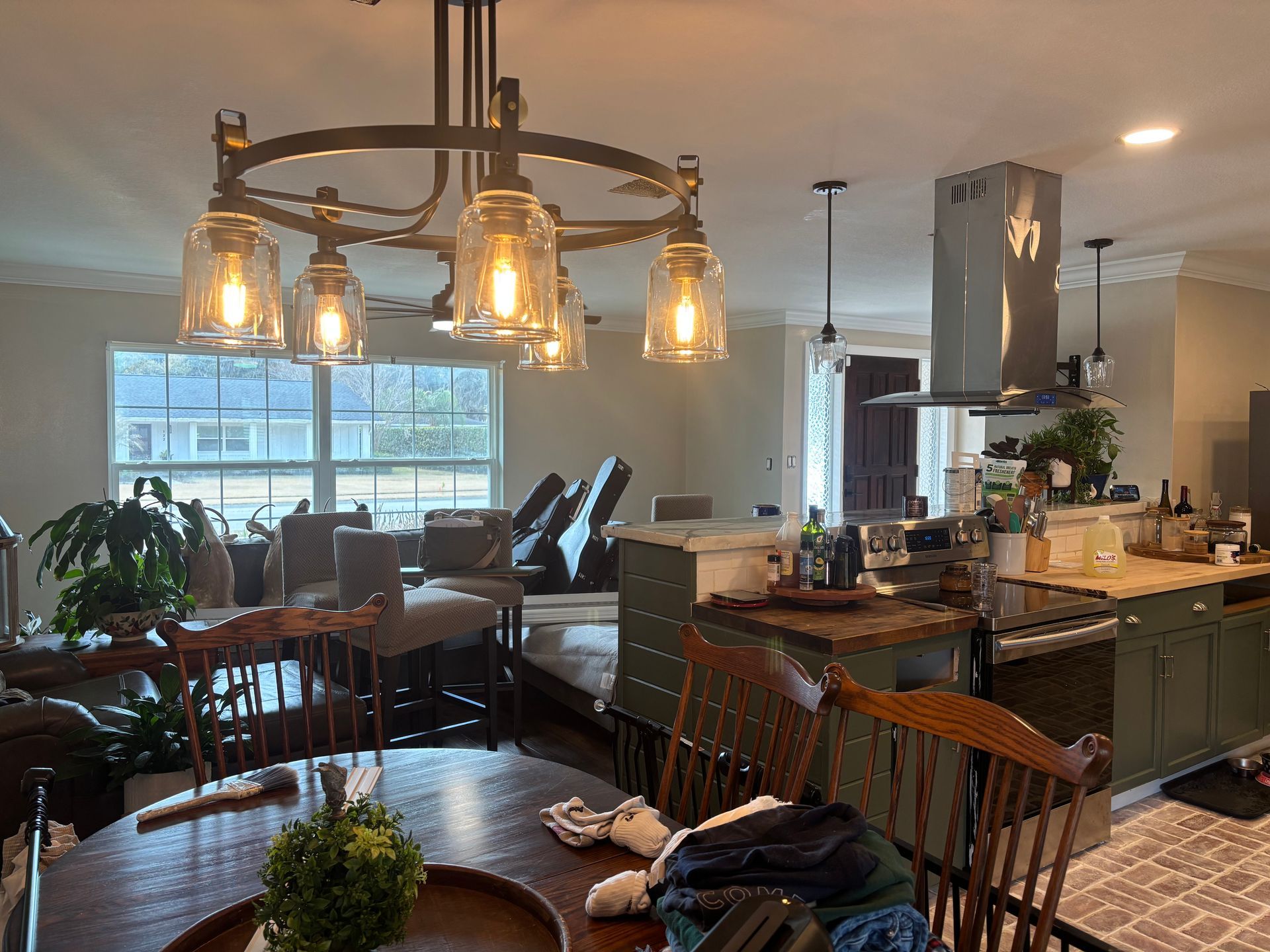 Warm kitchen and dining area with large island, hanging pendant lights, and a table by the window