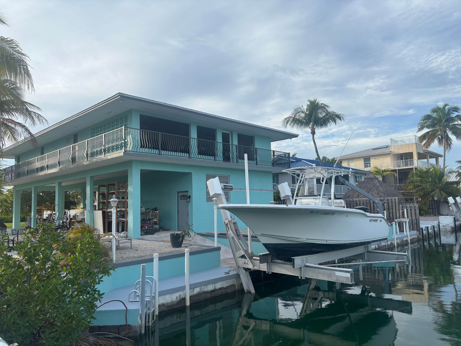 A man on a ladder is painting the side of a house.
