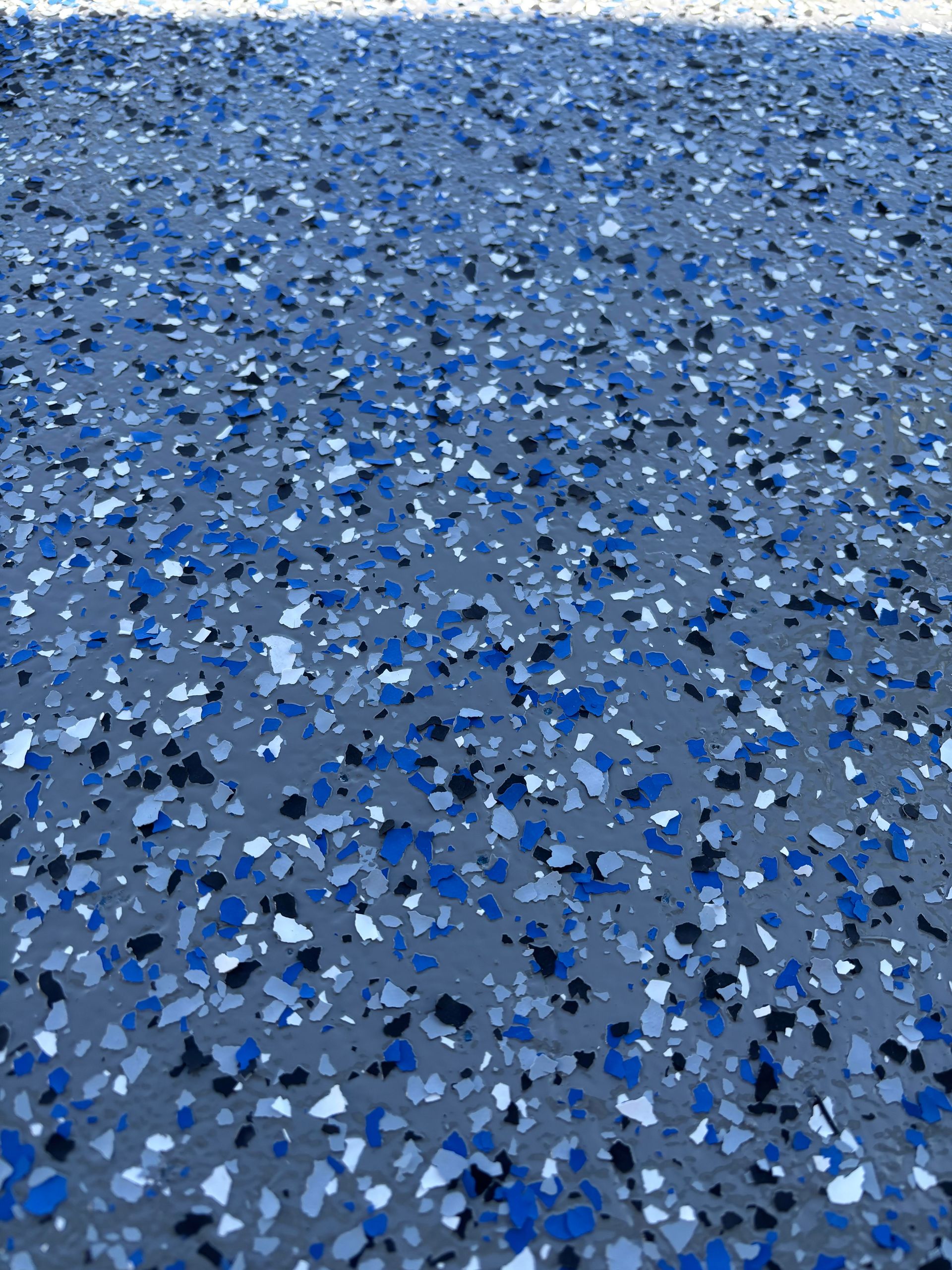 An empty garage with a garage door open and shelves.