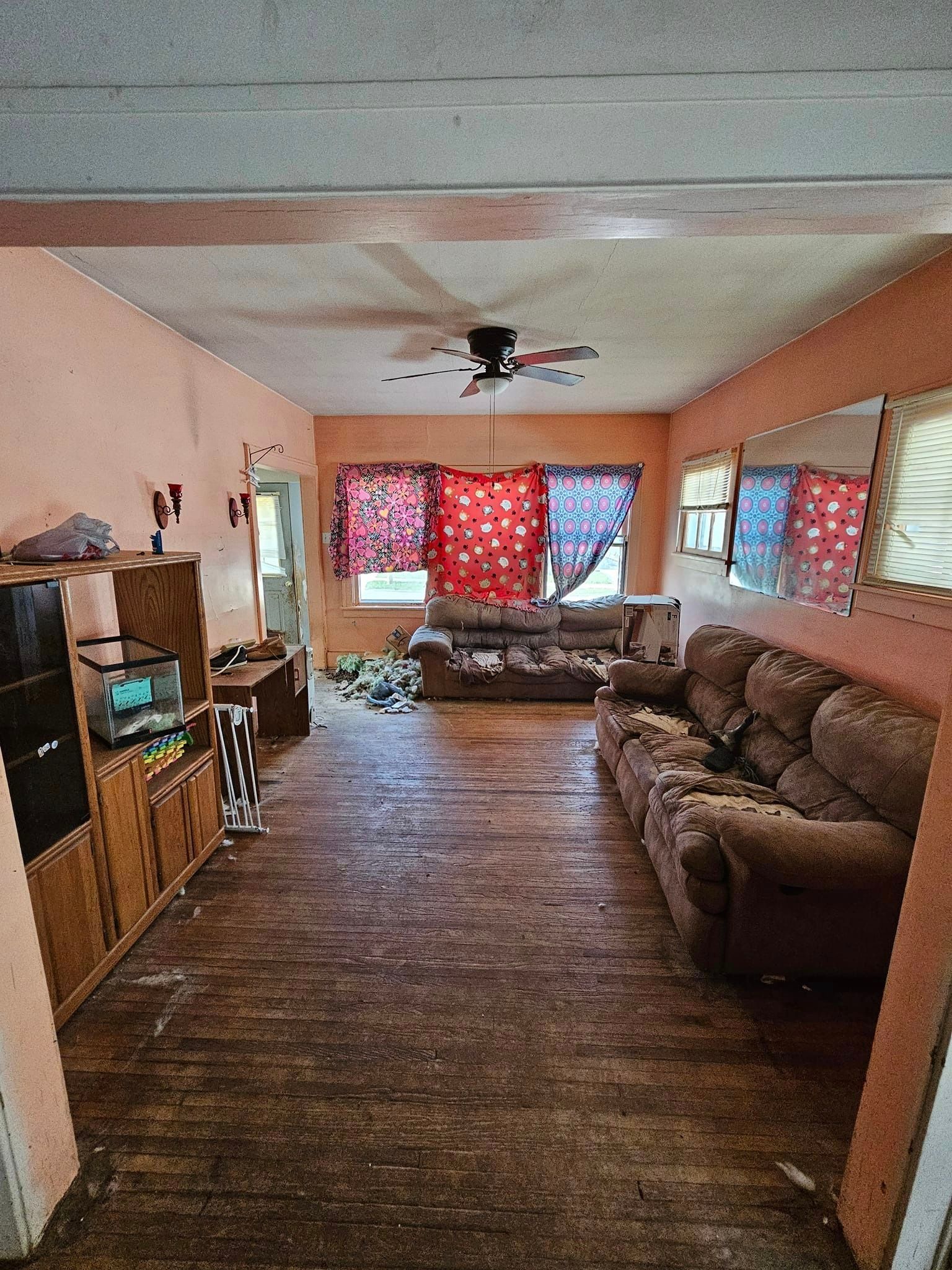 A living room filled with furniture and a ceiling fan.