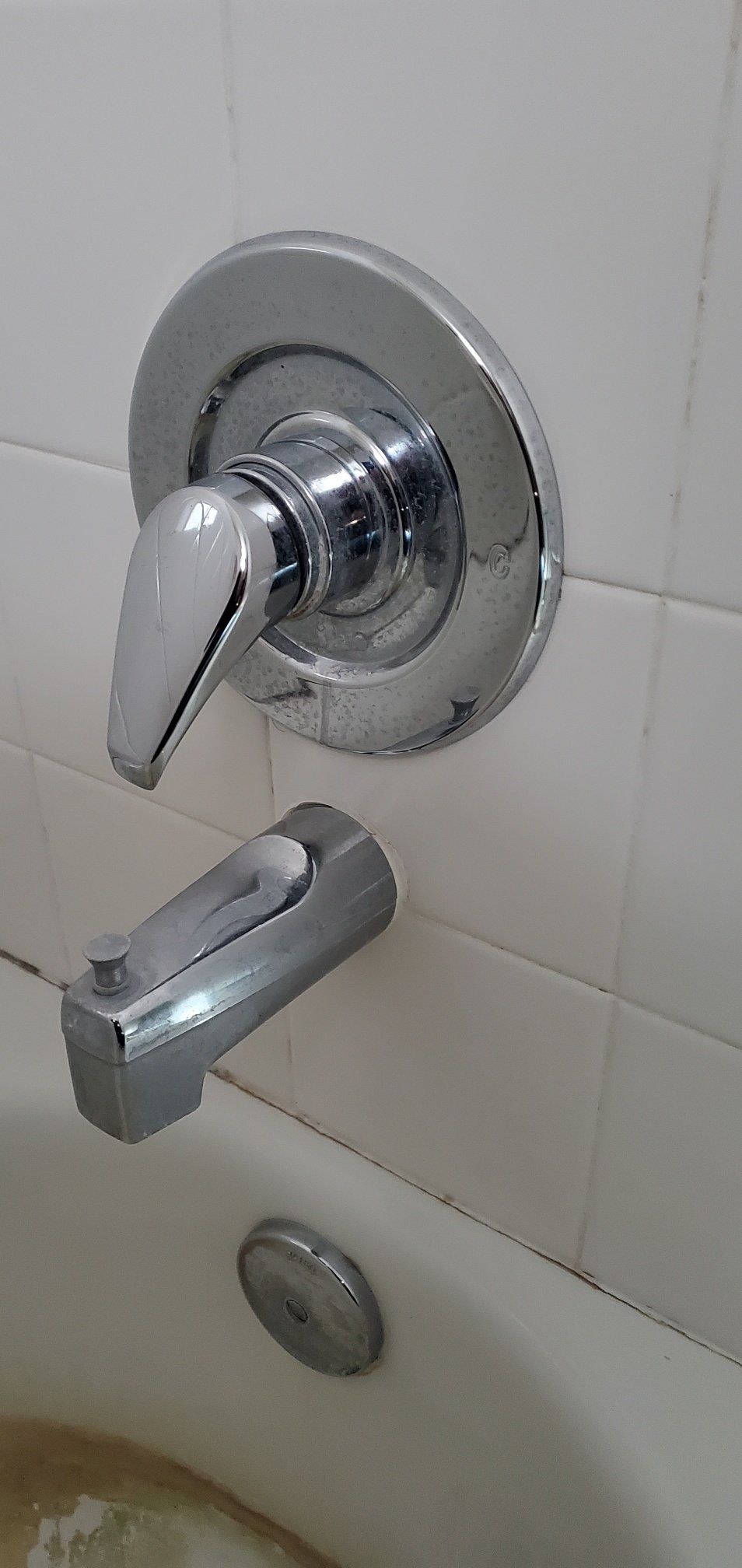 A close up of a bathtub faucet in a bathroom.