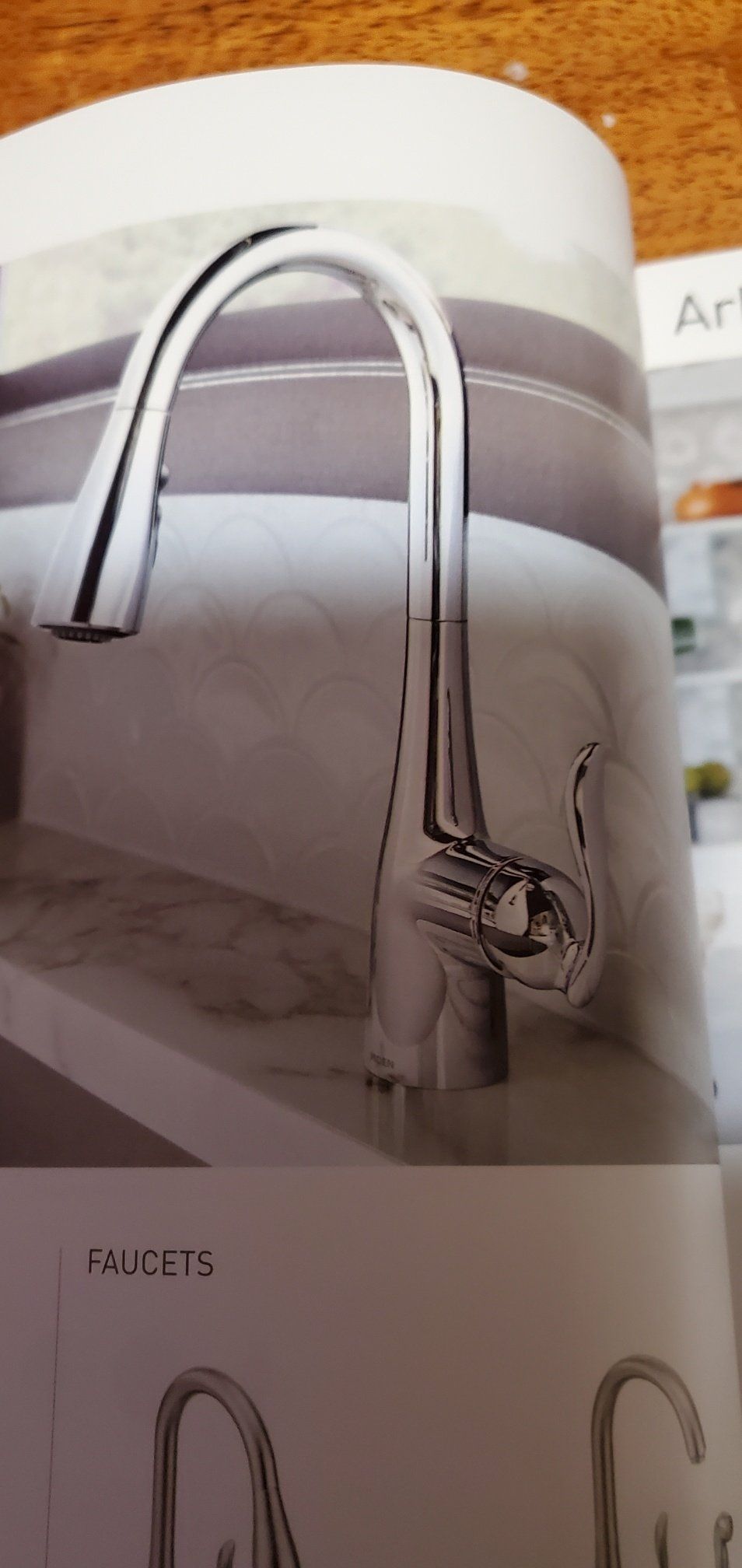 A close up of a kitchen sink faucet in a brochure.