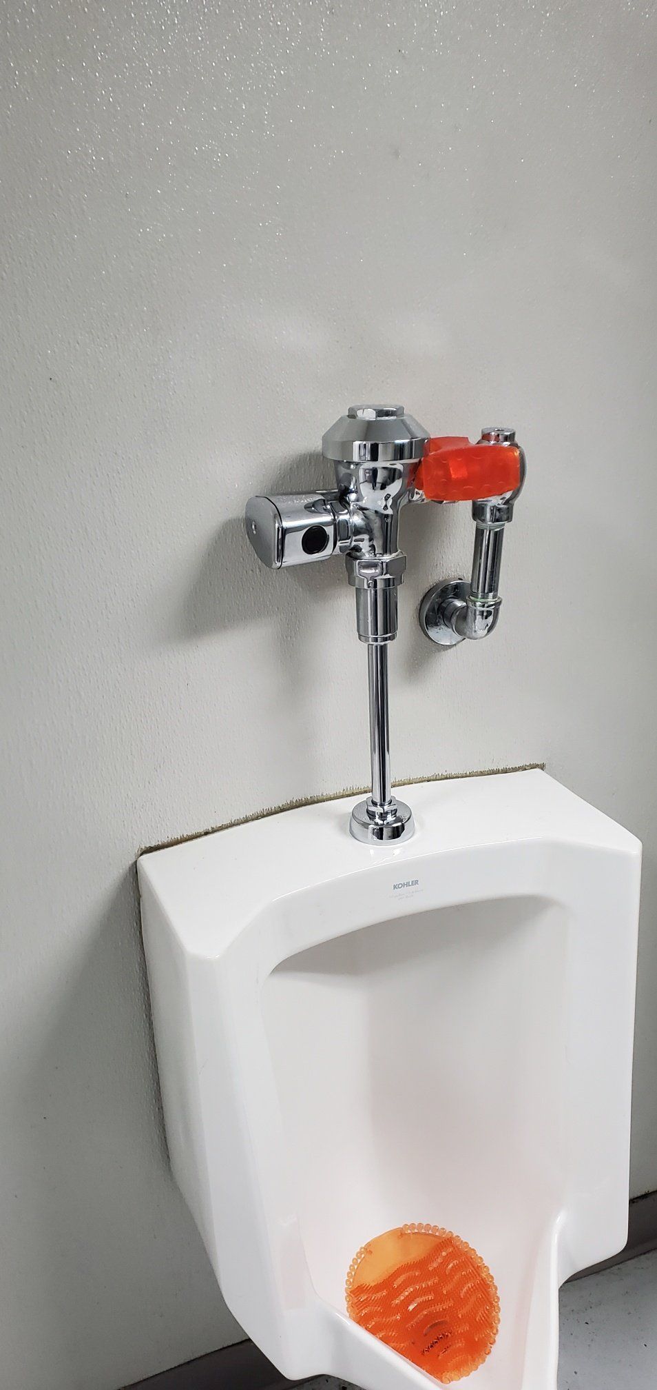 A urinal in a bathroom with a sponge in it.