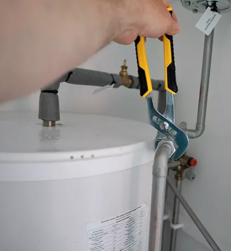 A person is fixing a water heater with a pair of pliers