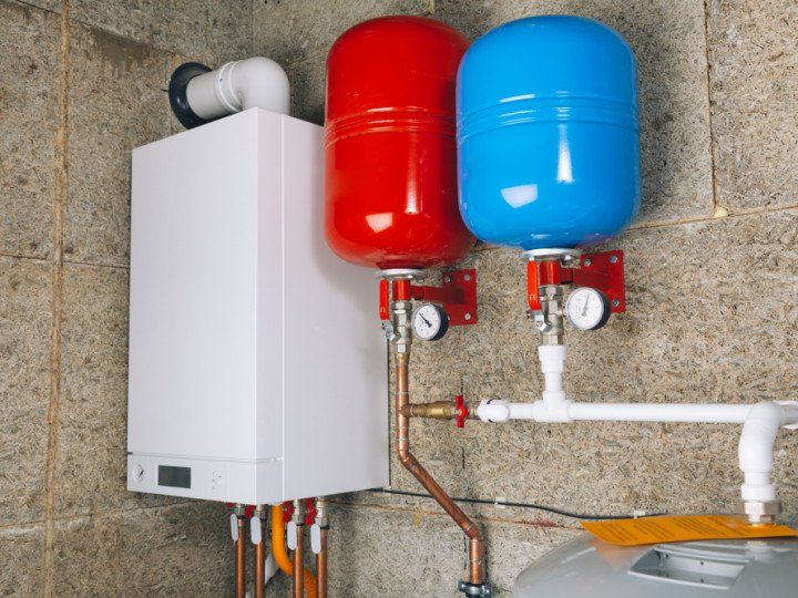 A boiler with two red and blue tanks attached to it.
