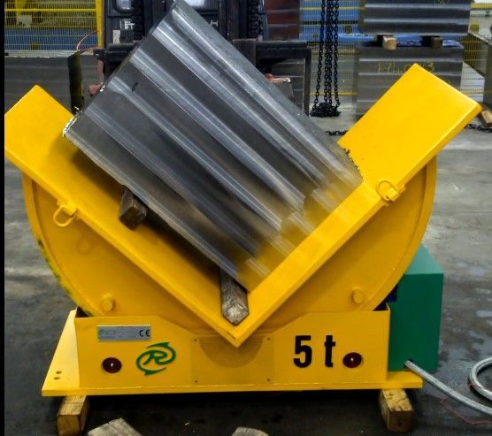 Macchina industriale inclinabile di colore giallo, contenente un grande cilindro metallico scanalato; la macchina è etichettata