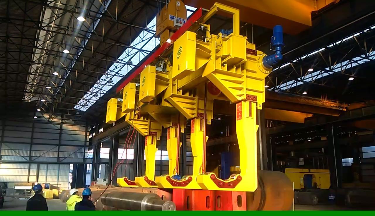 Macchinari industriali gialli in fase di assemblaggio all'interno di una grande fabbrica.