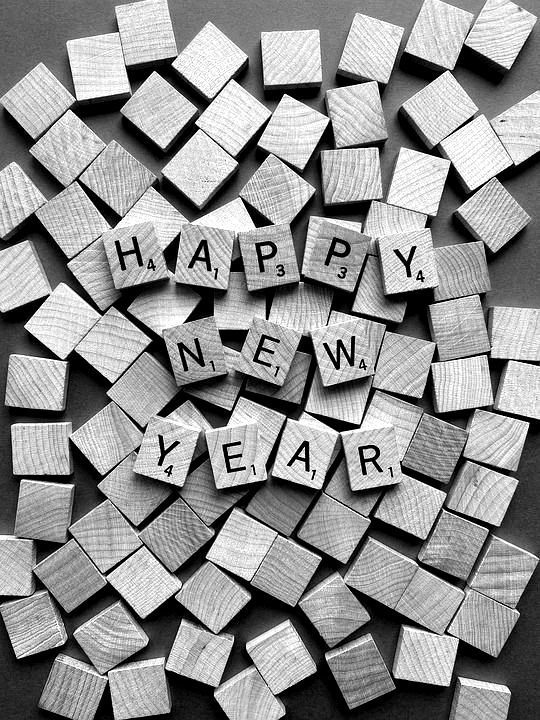 Des lettres de Scrabble formant l'expression « Bonne année » entourées de blocs de bois éparpillés.