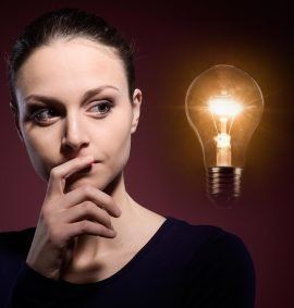 A woman is thinking with a light bulb in the background. A woman is thinking with a light bulb in the background.