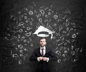 A man in a suit and tie is standing in front of a blackboard with a graduation cap on his head. A man in a suit and tie is standing in front of a blackboard with a graduation cap on his head.
