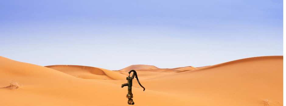 A water pump in the middle of a desert.