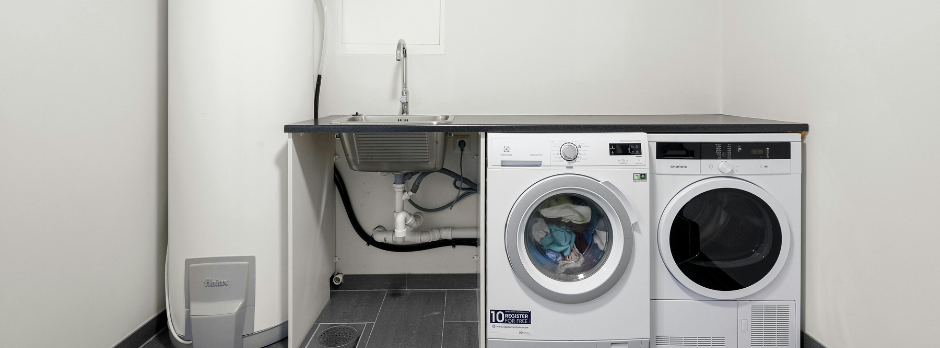 A washer and dryer are sitting on a counter in a laundry room.