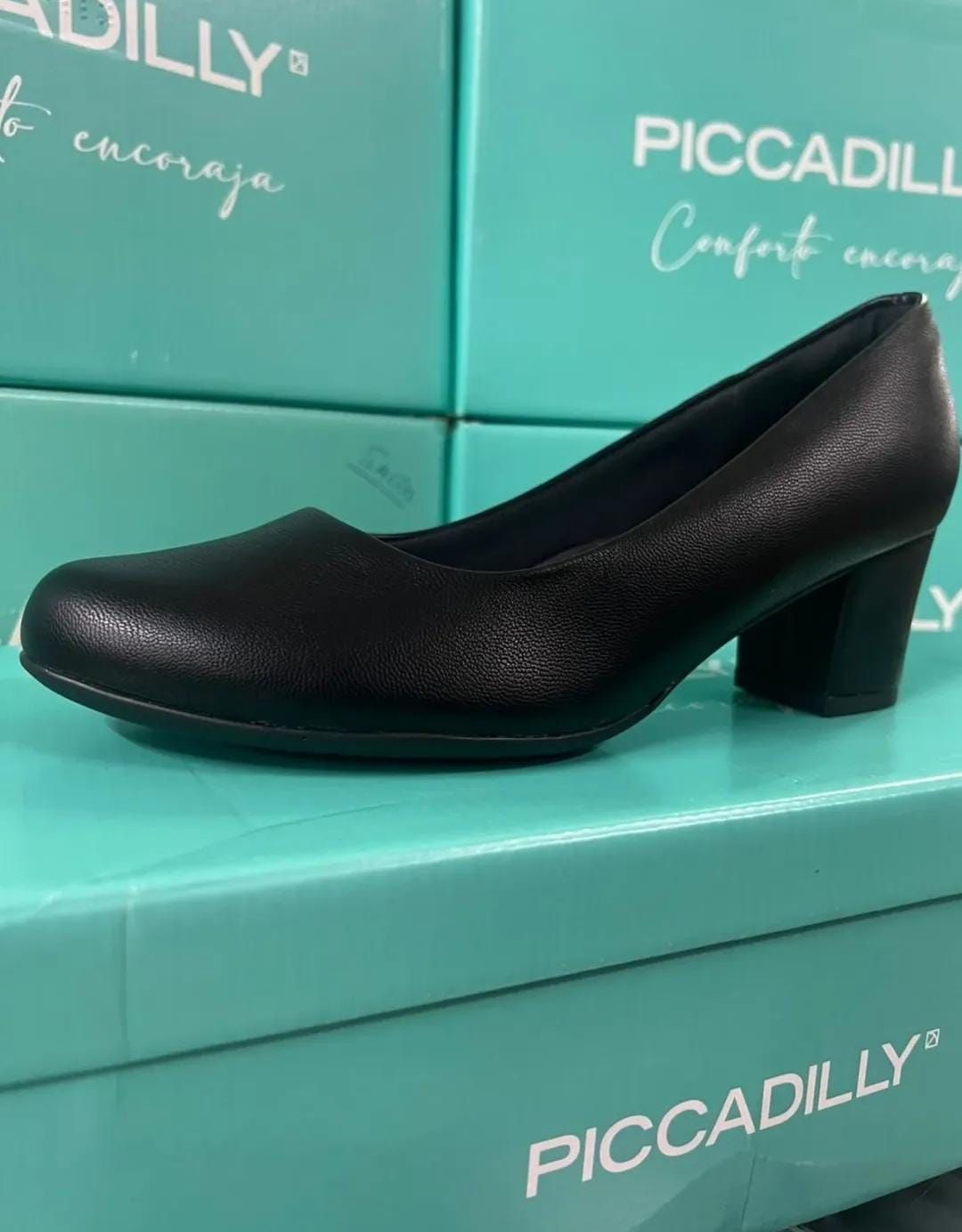 Zapatos de tacón alto negros sobre un fondo turquesa de una caja de Piccadilly.