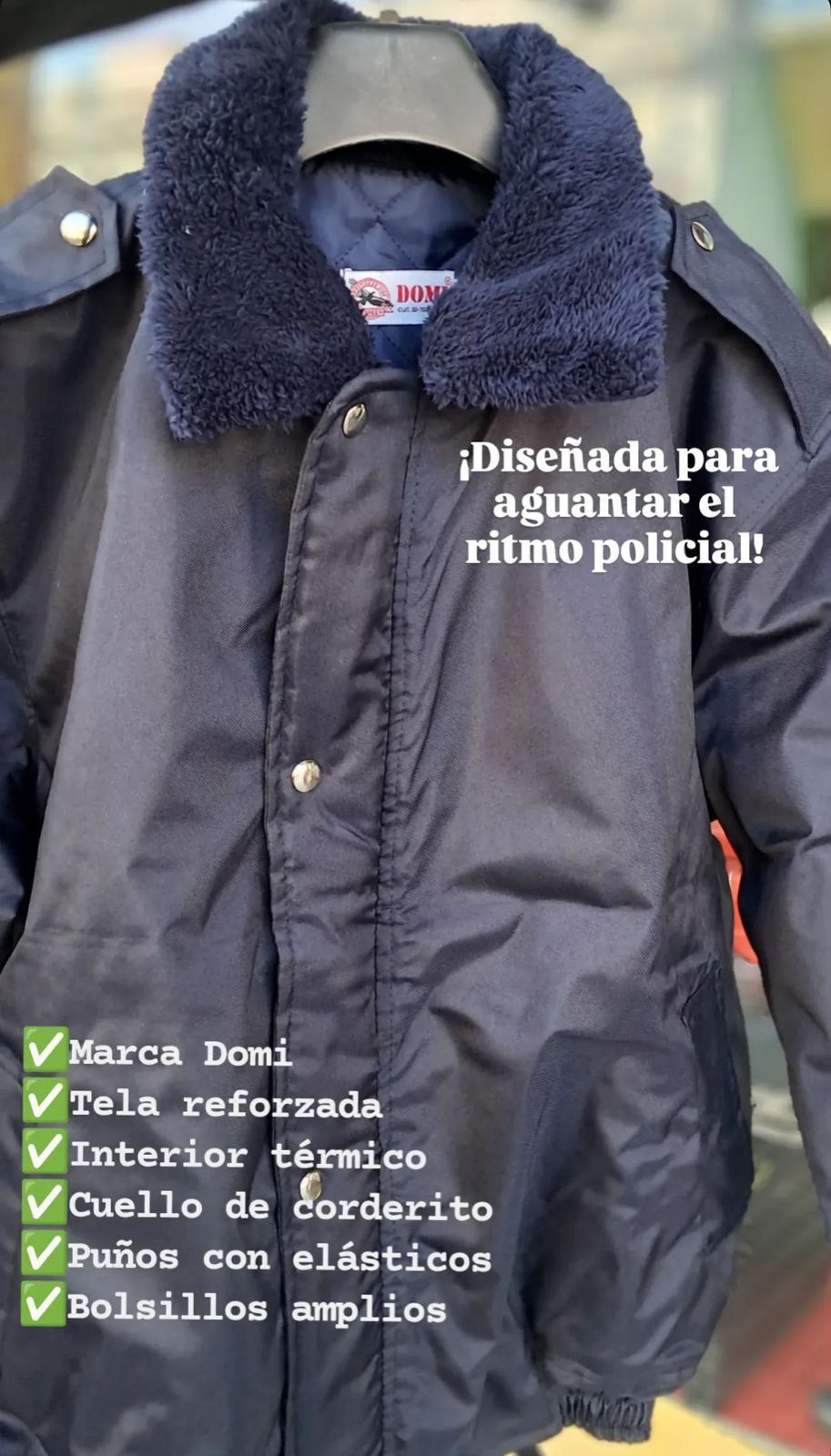 Chaqueta negra forrada con cuello de borrego y texto promocional en español, colgada en un perchero.