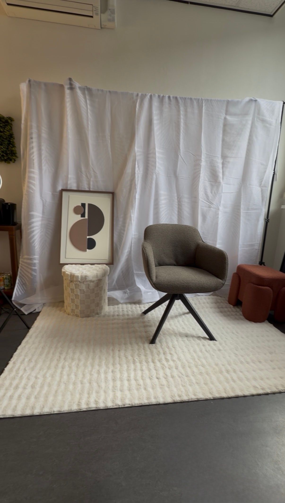 Gezellig ingerichte kamer met een witte gordijnachtergrond.