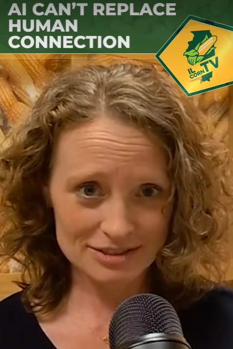 Woman with curly hair speaks into microphone; text 