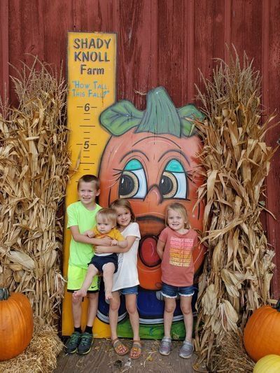 Children standing in front of a sign that says shady knoll farm