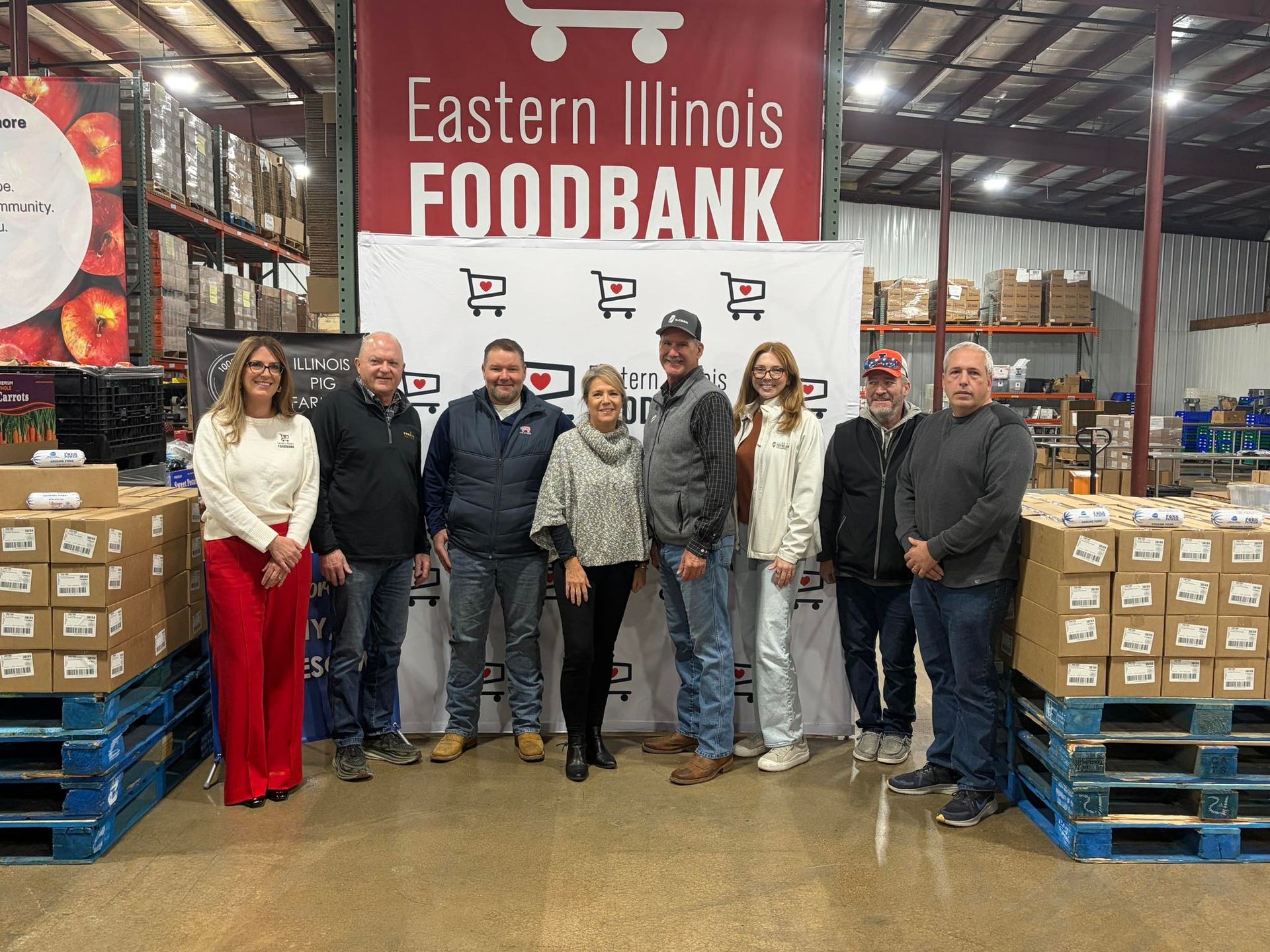 foodbank donation - farmers standing in front of a sign at a food bank