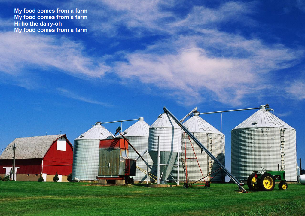 Farm silos and barns under a blue sky, with a tractor in a green field.