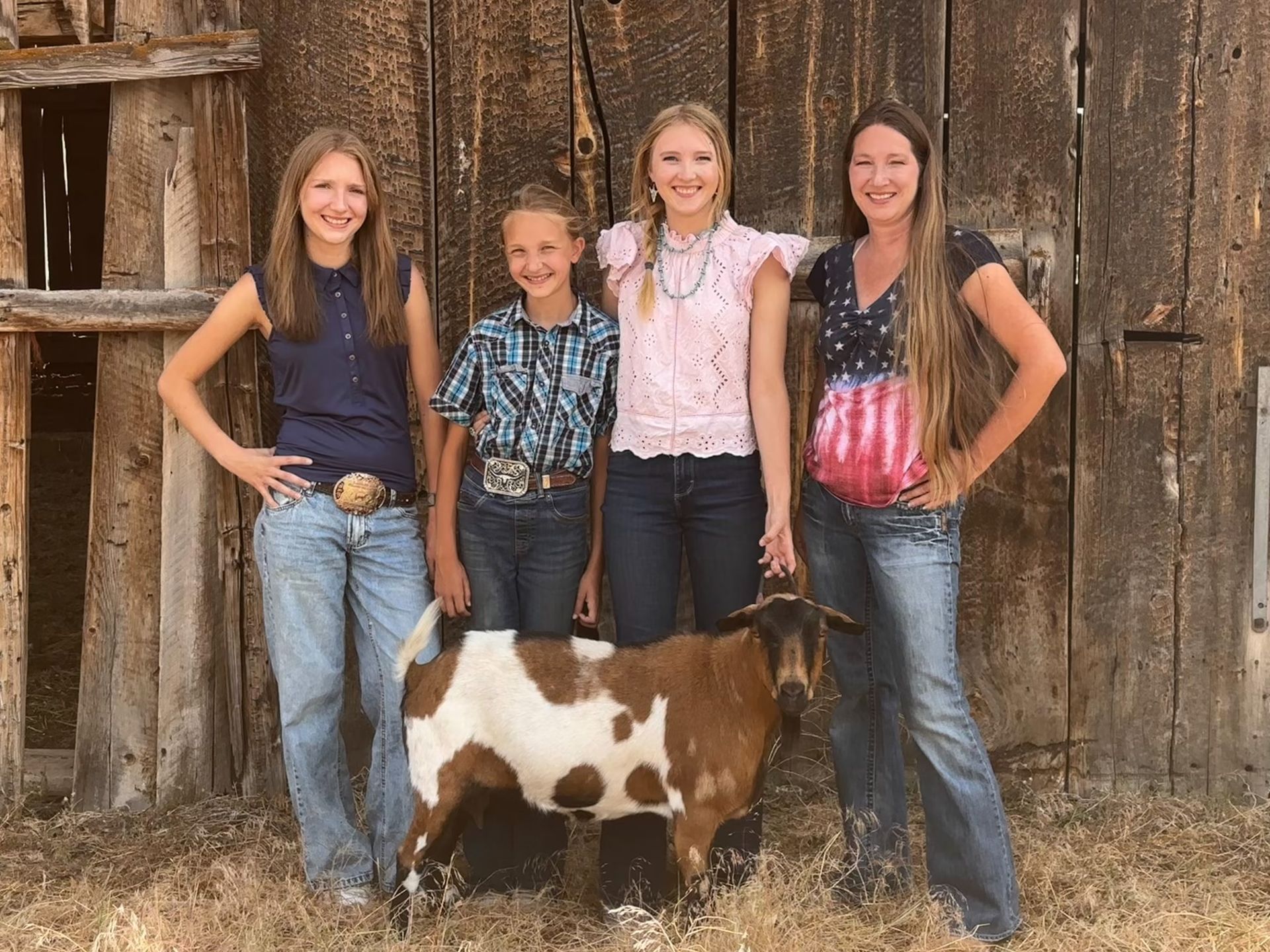 young ladies on a farm with a goat