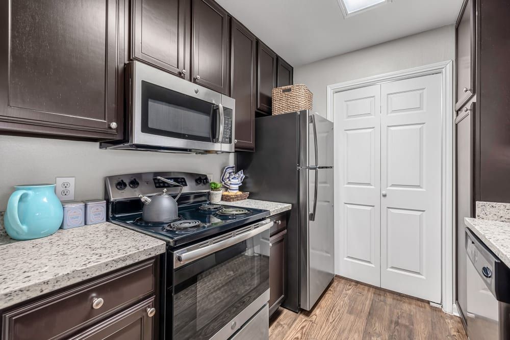 a kitchen with a stove, refrigerator, microwave, and sink at Marquis on Westheimer in Houston, TX.