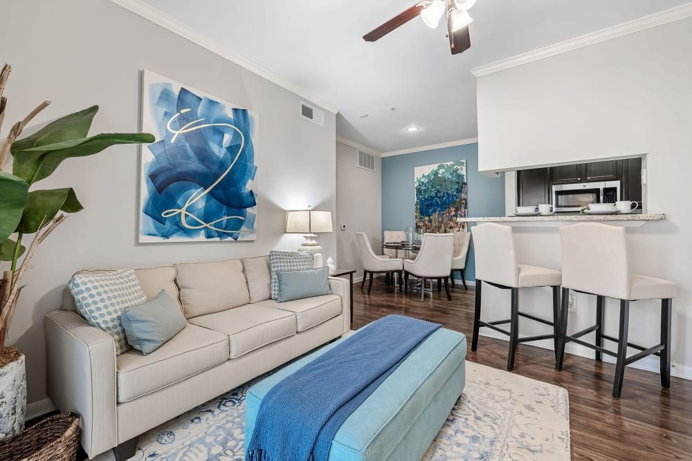 a living room with a couch, ottoman, chairs, and a ceiling fan at Marquis on Westheimer in Houston, TX.
