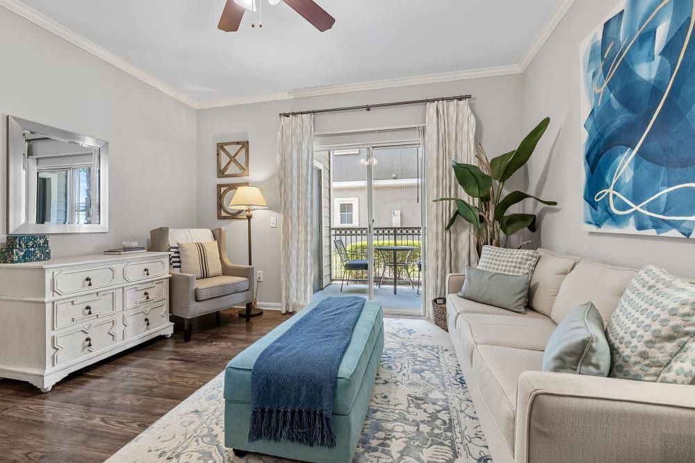 a living room with a couch, chair, dresser, and ceiling fan at Marquis on Westheimer in Houston, TX.
