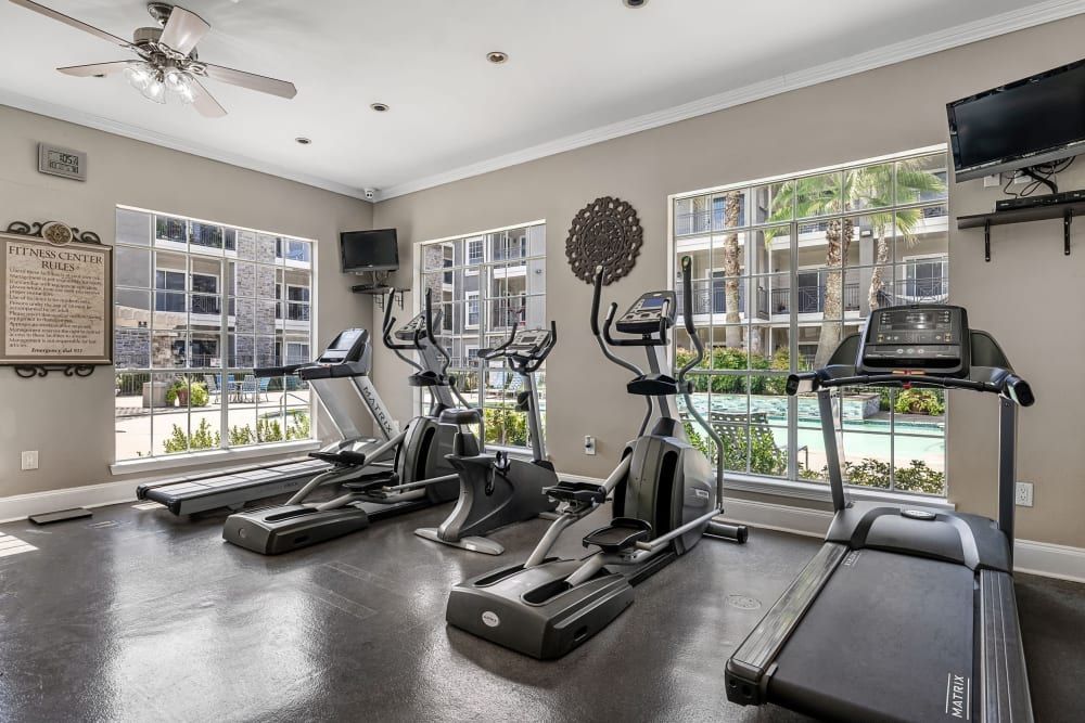 a gym with treadmills, ellipticals, and a ceiling fan at Marquis on Westheimer in Houston, TX.
