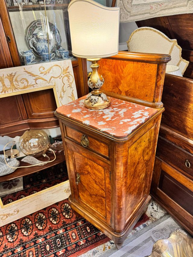 Una lampada è appoggiata su un comodino di legno.