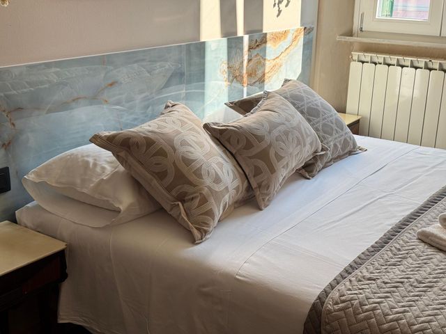 Una camera da letto con una lampada sul comodino e una finestra
