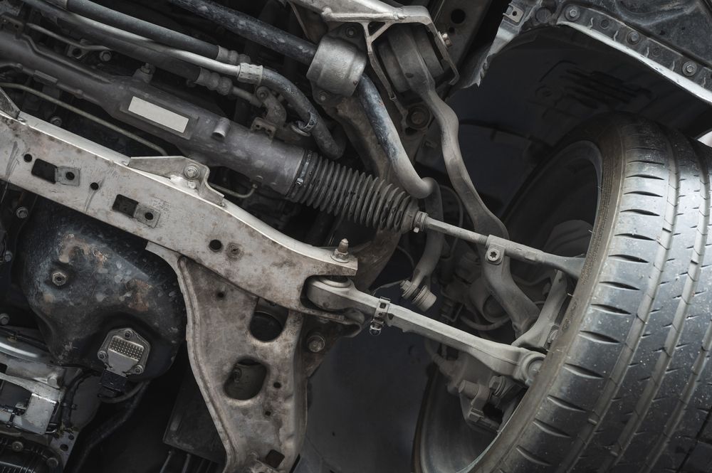 Undercarriage of A Vehicle, Showing Suspension Components, Steering Rack, and Tire — Erina Mechanical Repairs In Erina, NSW