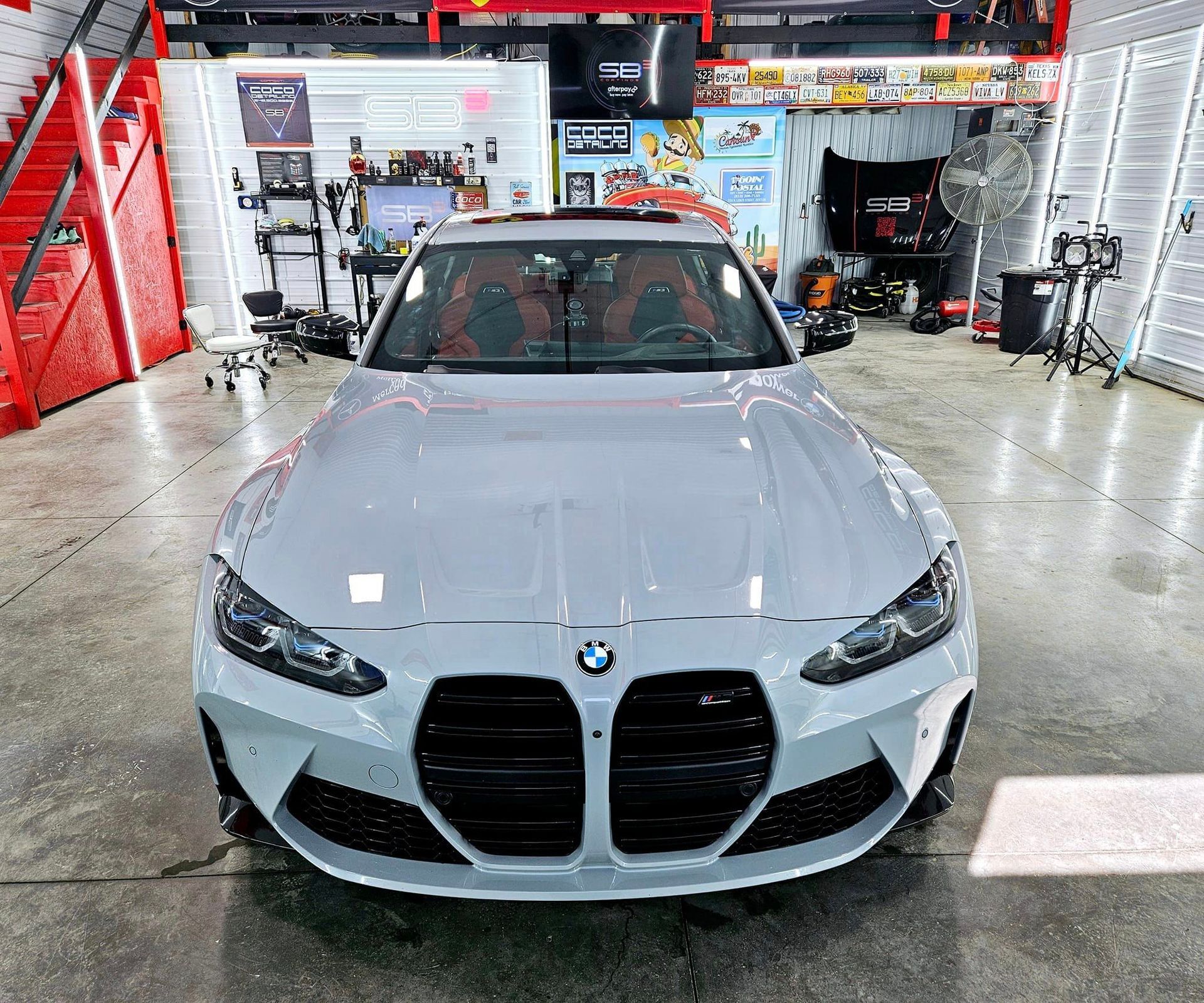 A white bmw m4 is parked in a garage.