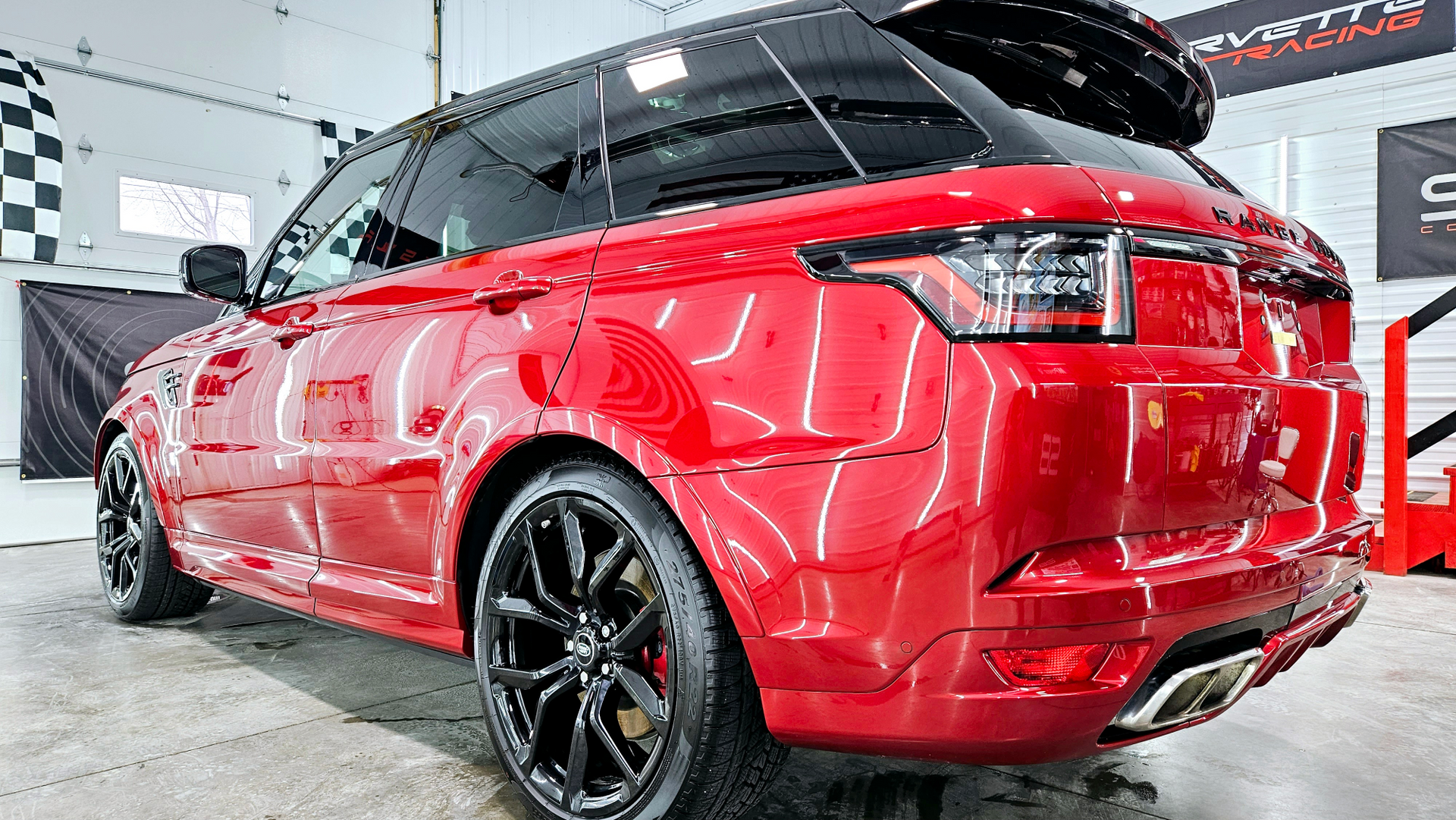 A red range rover sport is parked in a garage.