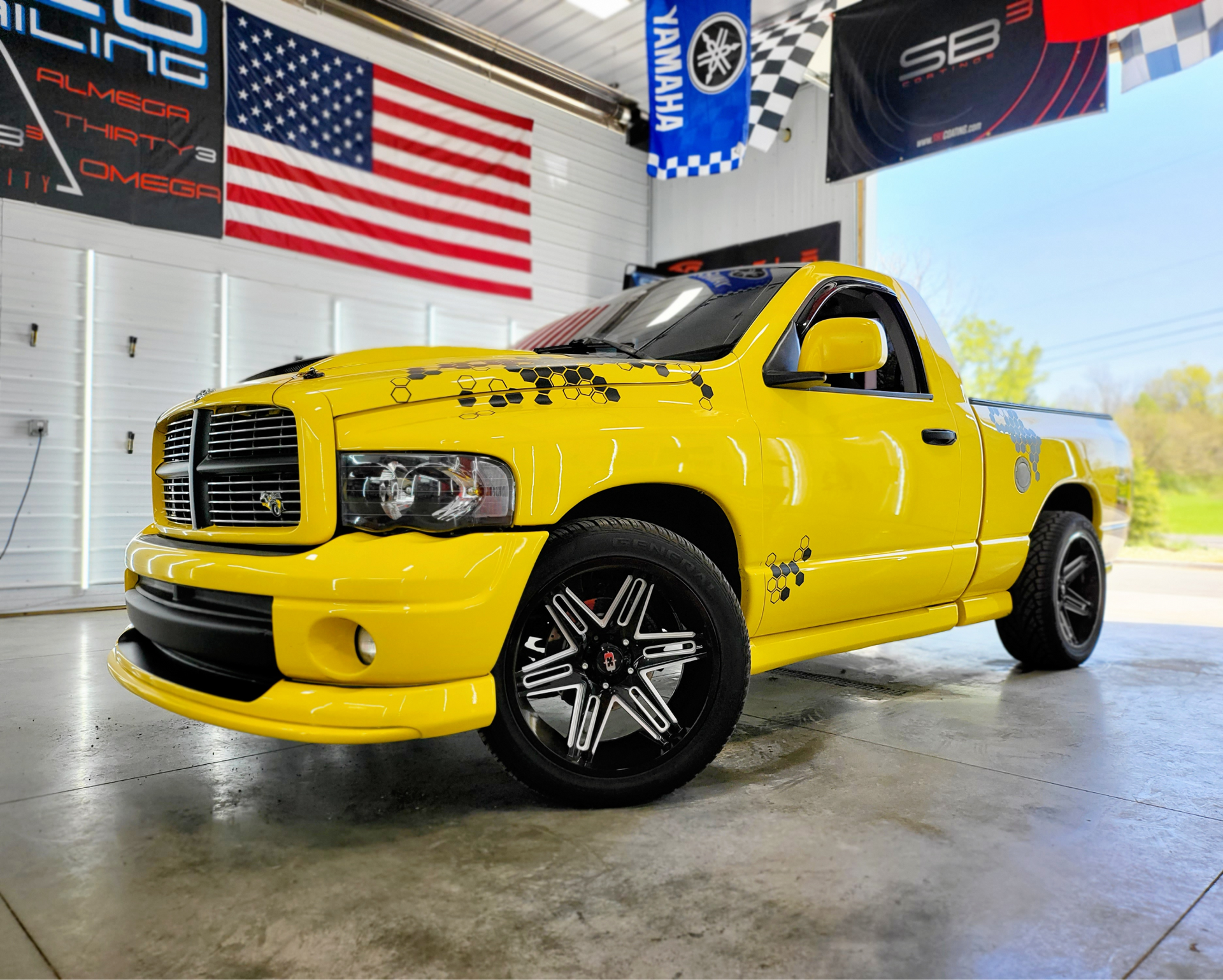 A yellow dodge ram truck is parked in a garage.